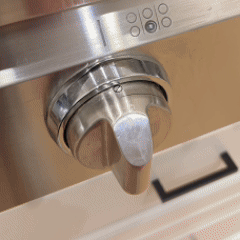 A stove knob turned on, followed by the range hood activating automatically